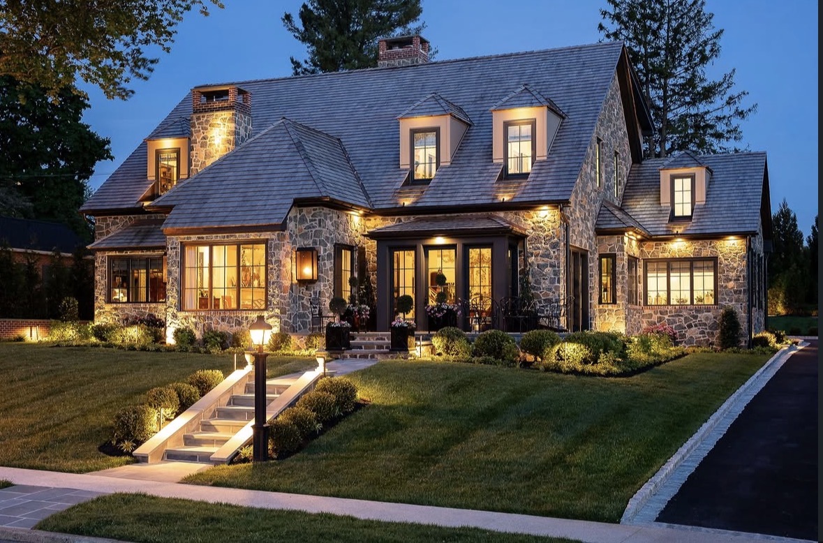 Custom stone home illuminated at dusk by Bromwell Electric